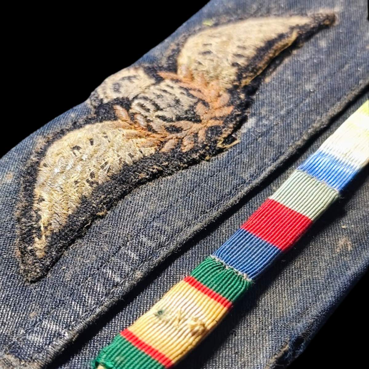 Close Up of Original RAF navigator wings wallet with mounted ribbon bar from WWII medal group to J.C. Elphick, showing service wear.